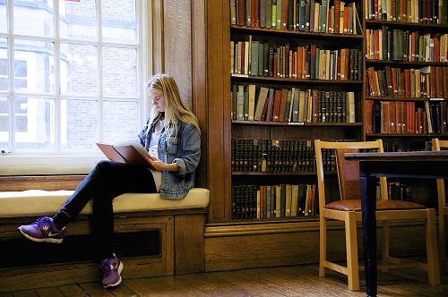 student reading a book in the library